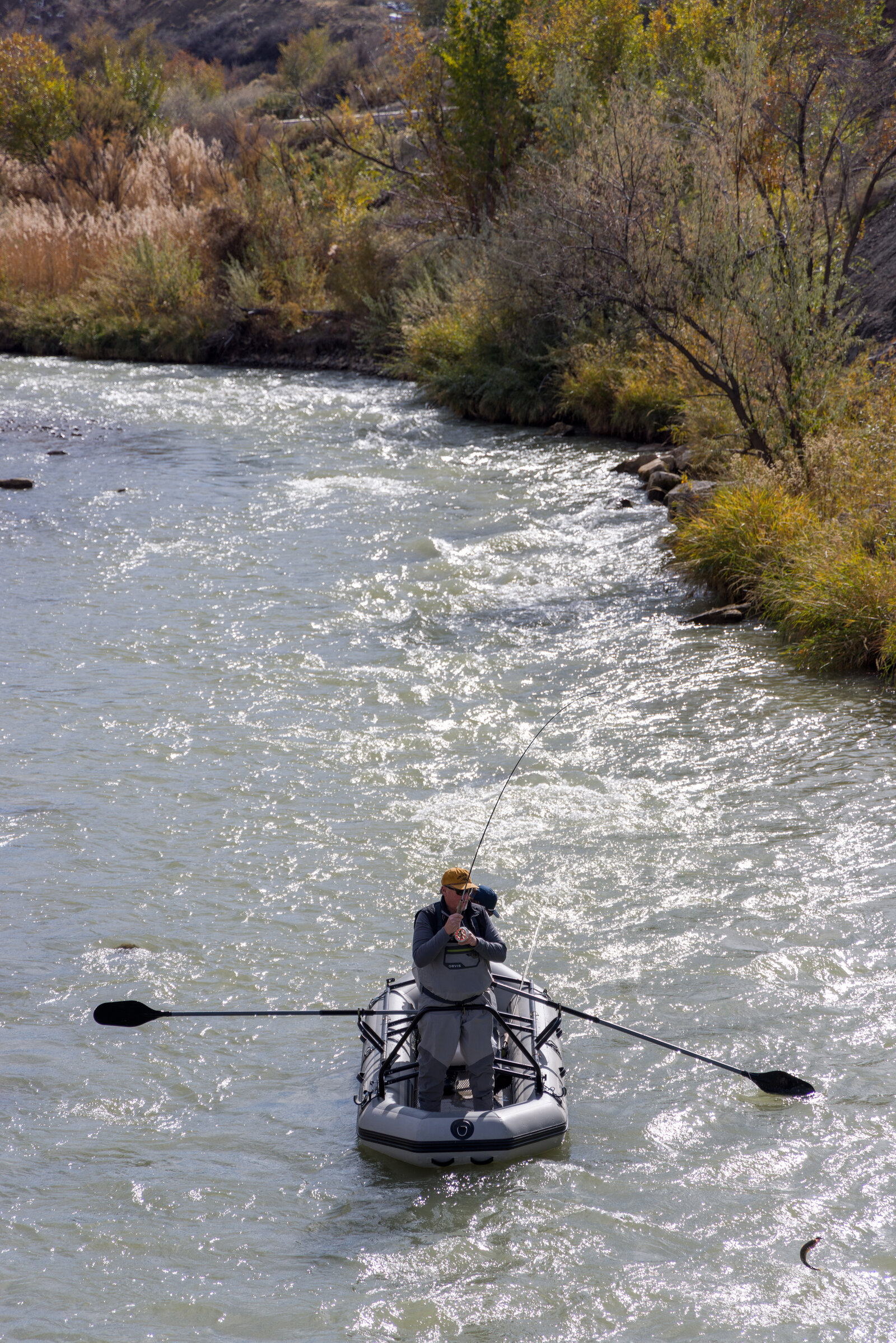An angler standing and casting from a SmithFly raft on a river